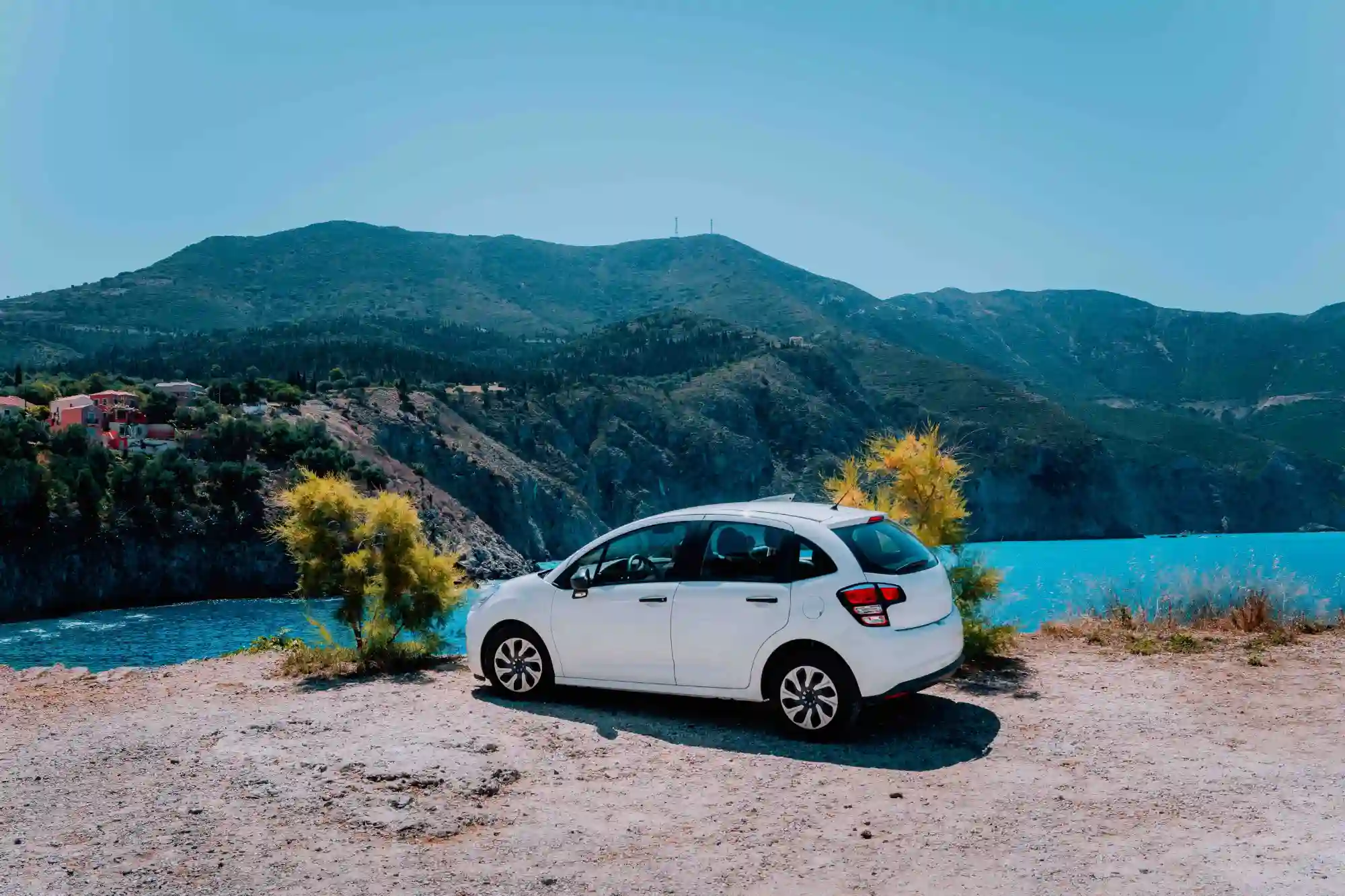 Urlaubsreisen mit Auto Fotograf Hannover. Mieten Sie einen Mietwagen vor einer atemberaubenden Bucht mit türkisfarbenem Wasser. Entdecken Sie Mittelmeerinseln. Sommerurlaubsreise.